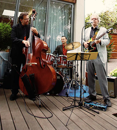 Foto einer Trio-Besetzung als "Trio 2" mit Tobias Langguth, Gitarre/Gesang, Dirik Schilgen, Schlagzeug und Johannes Schaedlich, Kontrabaß.